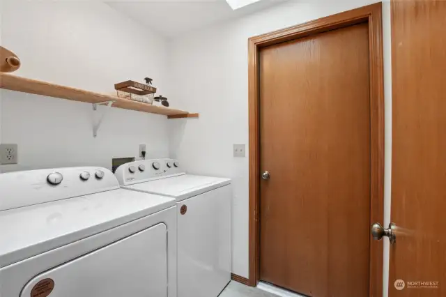 Well-appointed utility room can double as a mud room. It opens into the garage on the right and into the corridor on the left. The washer/dryer set is just 6 year old.