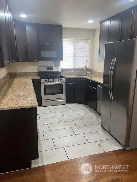 The main living area has a large modern kitchen with added natural light from the window.