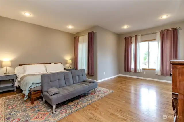 Spacious primary bedroom with indirect lighting and large windows.