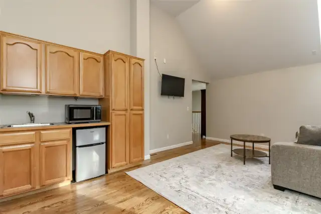 Bonus room off the upper landing leads into bedrooms 4 & 5. You can see built-in sink, microwave and mini-frig. Plenty of room for lounging and watching TV.