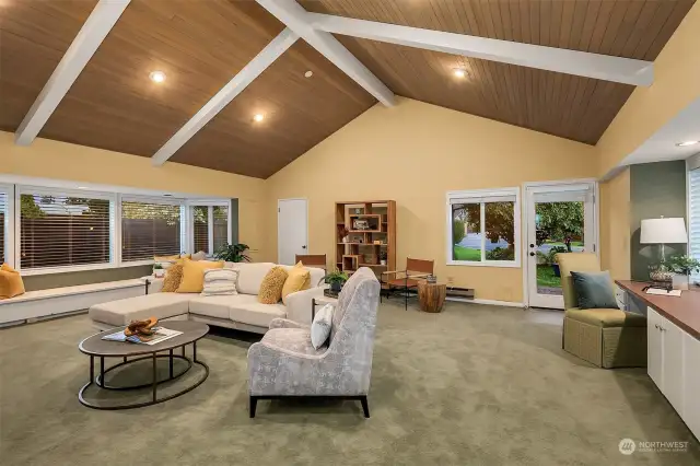 At the rear of the house is a very large rec room with loads of windows, vaulted ceilings and custom lighting. Notice the window seat and the build in storage and work space!