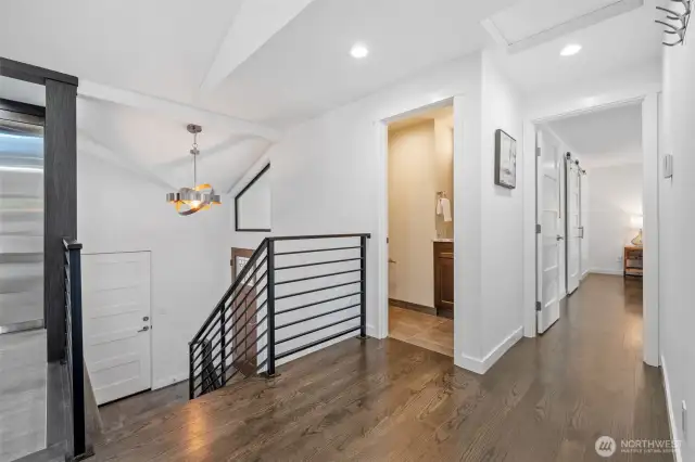 This bright and open hallway connects the upper and lower levels, creating an efffortless flow throughout the home. Downstairs, you'll find a spacious family room, a convenient utility room, and two additional bedrooms, perfect for versatile living.