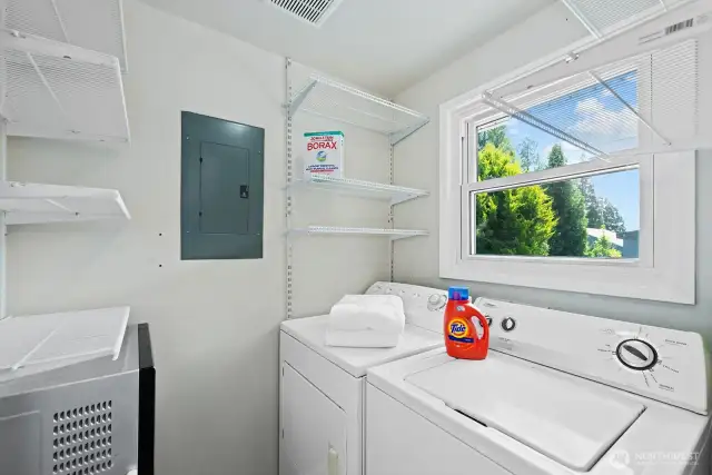 Just off the kitchen find a full size laundry room with shelving for pantry items.