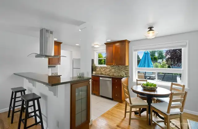 Flooring transitions to ceramic tile in the kitchen. Note the built in cabinet with glass door.
