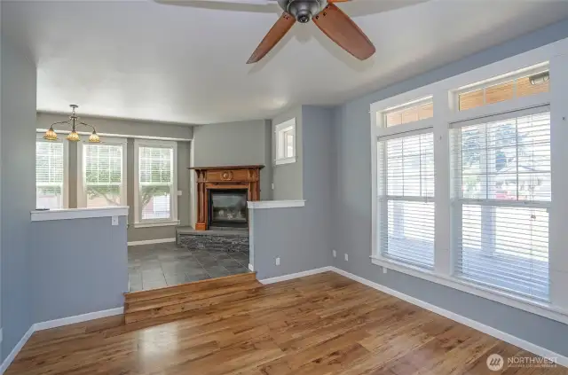 Look up from the living area into the dining room, where a gas fireplace with a timeless wood mantel adds charm and warmth.