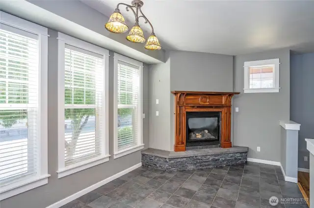 Gather in the dining area, where a gas fireplace with a rich wood mantel adds the perfect touch of elegance and comfort.