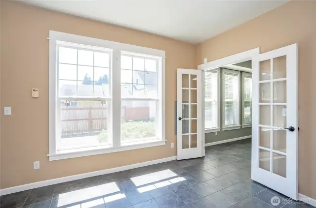 Step through French doors into a sunlit den or office, perfect for work or relaxation.