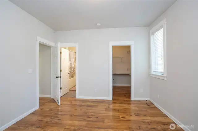 The main-level primary suite boasts a private ensuite and a roomy walk-in closet for added comfort and convenience.