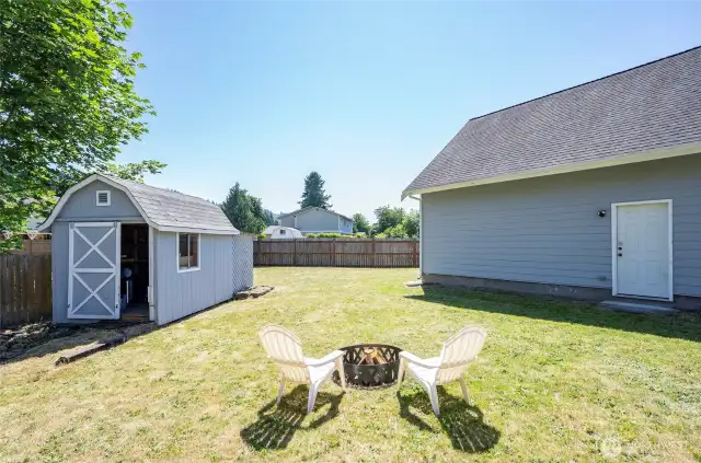 Unwind around the firepit and keep things tidy with the added storage shed—both perfect additions to this functional backyard.