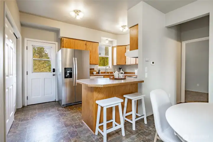 Kitchen with newer fridge, back door, and laundry closet to the left.