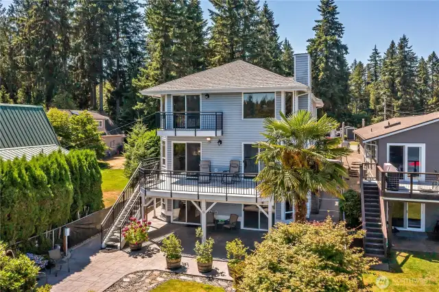 Back of the home with paver patio and potted blueberries that stay for Buyer!