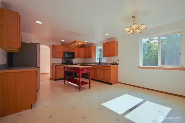 Large Kitchen with island, lots of cabinets and breakfast nook area. Along with another arched way to dining area.