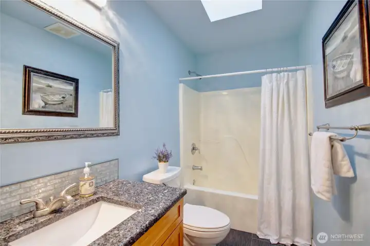 Full guest bath between bedroom 2 & 3. It is bright and light filled from the skylight.