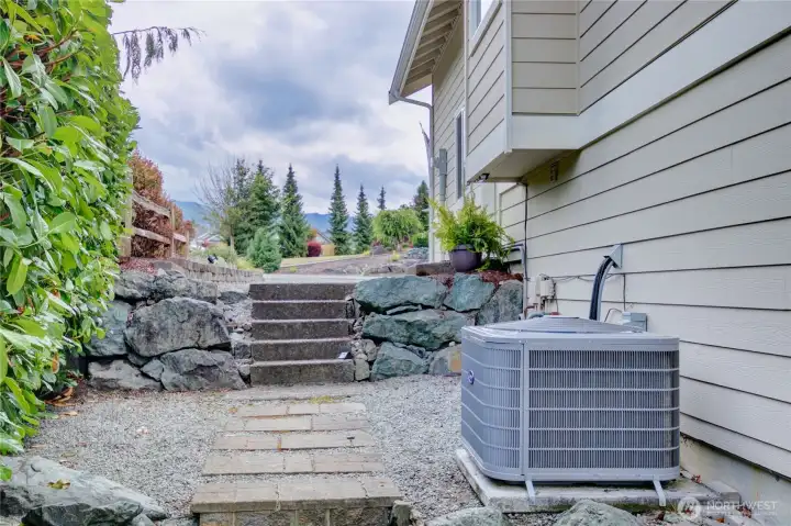 Steps and gradual walkway on the west side of the home lead from parking to the lower level entry.