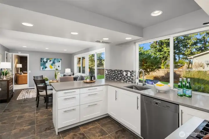 The remodeled kitchen features island seating and upgraded stainless-steel appliances, including a Miele 3-rack dishwasher, a Wolf dual-fuel range, and a French-door refrigerator (included).