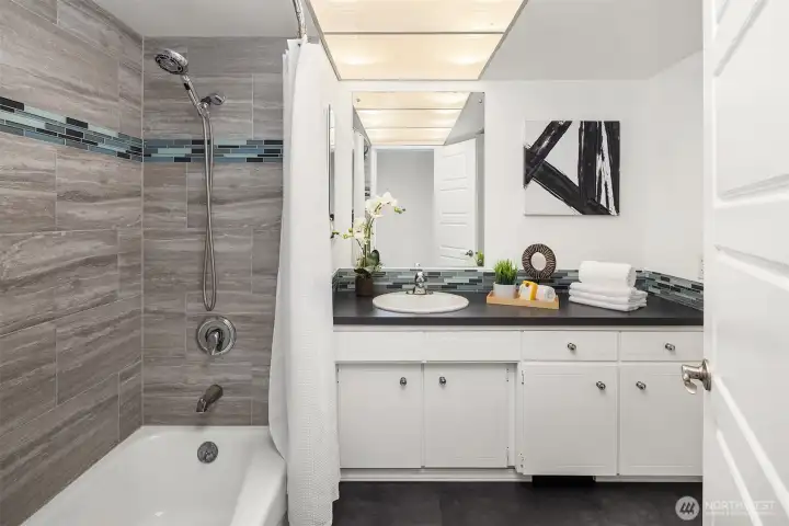 The remodeled upper-level hall bath offers generous storage and counter space.