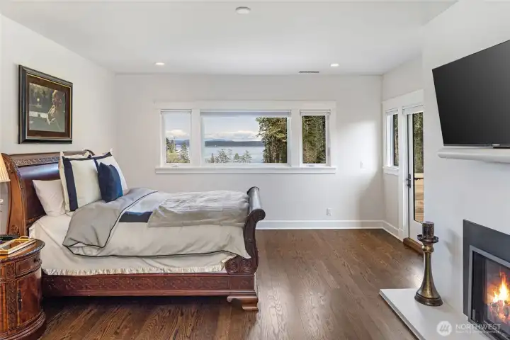 Generous guest suite with hardwood flooring, fireplace, and large picture windows overlooking the San Juan Channel and surrounding evergreens.