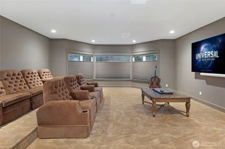 Private media room with tiered seating, plush carpet, and recessed lighting—ideal for cinematic entertainment within this luxury estate.