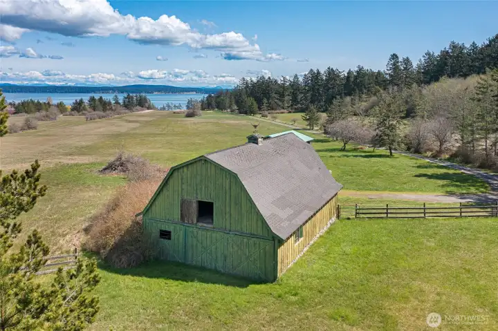 Charming historic barn overlooking the airstrip and San Juan Channel views—ideal for storage, hobbies, or agricultural use within this expansive island property.