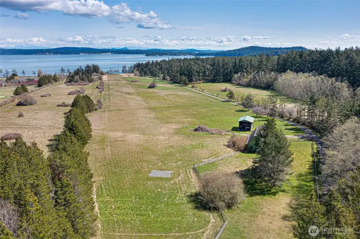 Private 2,400± ft FAA-certified runway bordered by open pasture and mature forest, with historic barn and outbuildings enhancing the estate’s legacy character.
