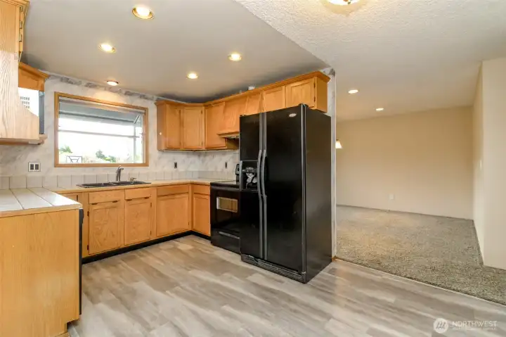 Kitchen with updated LVP flooring and garden window.