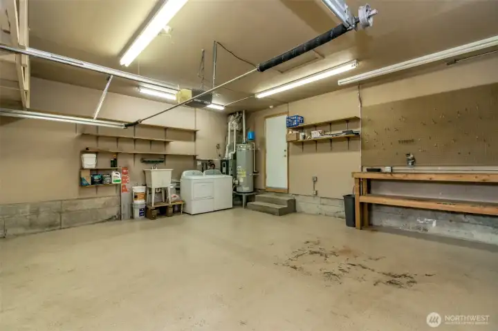 2 car garage with work bench, washer, dryer and storage shelves.