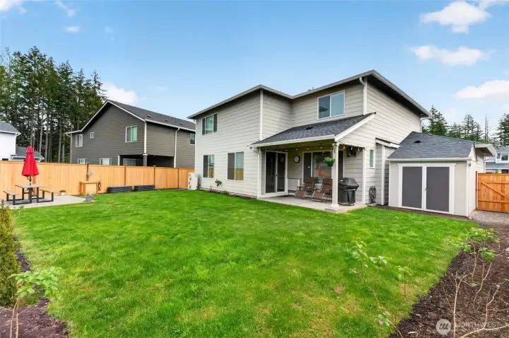 Large fenced backyard with storage shed with power, has built in sprinkler system, paver patio and irrigated vegetable garden.