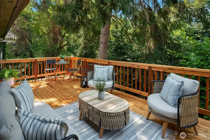 An expansive deck overlooks the tranquil, park-like setting, creating the perfect outdoor retreat for summer entertaining, relaxing, and enjoying the beauty of the Pacific Northwest.