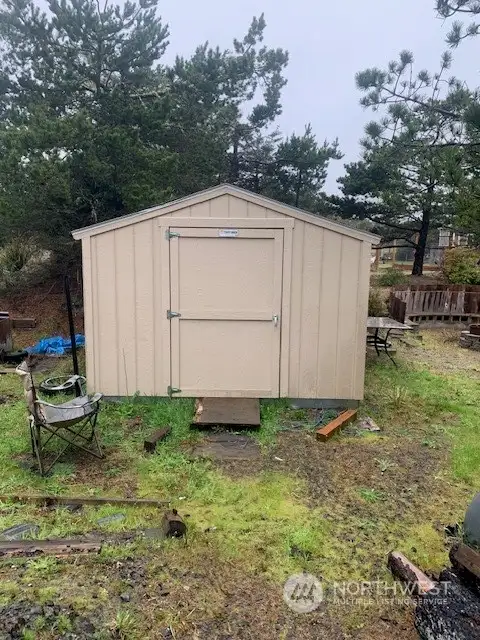 This large shed comes with the lot along with a stand-up freezer and small refrigerator.