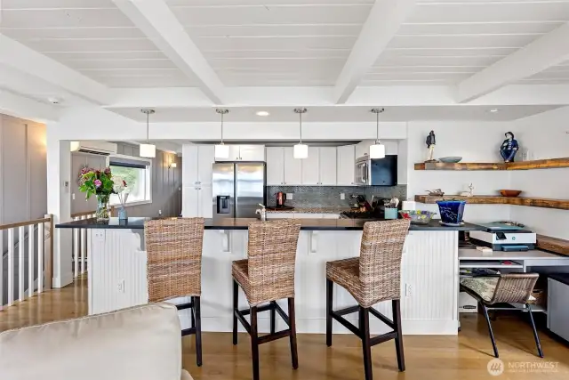 There is a  lovely eating bar where guests can sit and visit while the cook is prepping a meal. A desk to the right is the perfect place to keep yourself organized.