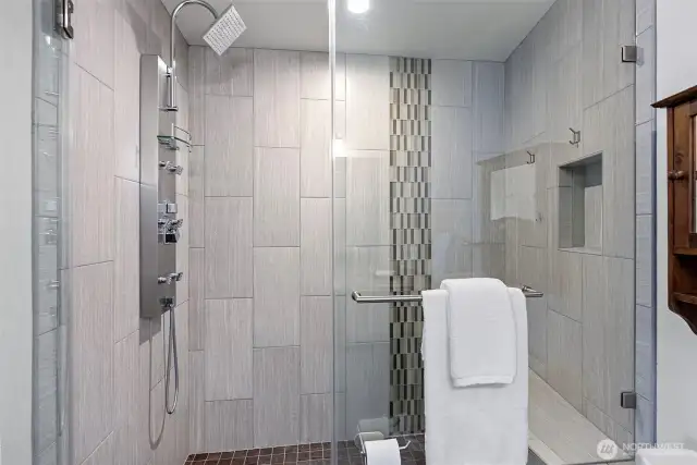 A gorgeous tiled shower and bench seating is a part of the primary bath.