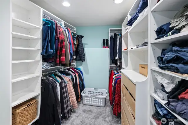The walk-in closet in the primary bedroom, which also houses the washer and dryer.