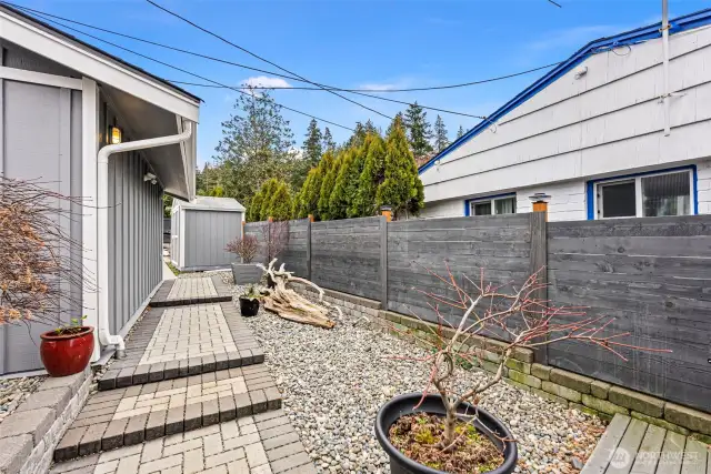 This is the side yard of the cottage. Notice the shed in the background for extra storage. It will remain with the home.