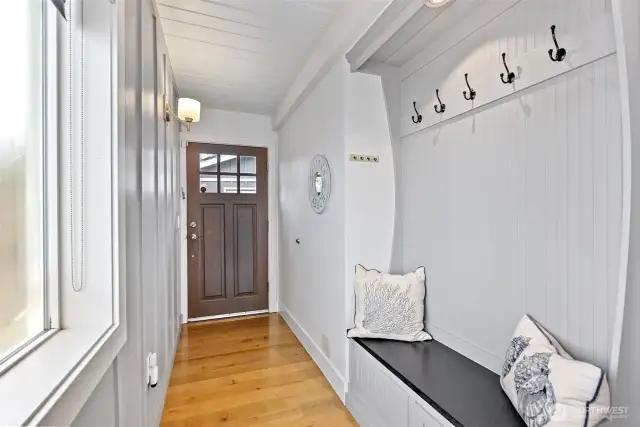Upon entering the home, you will be captivated by the cottage feel and beach vibe captured in the decor as well as the beautiful oak flooring. A hall tree allows for easy storage of coats and hats. (The window to the left is in the process of being replaced.)
