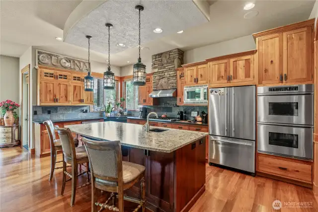 Gorgeous fixtures & stone detail adorn this designer kitchen.  Double ovens, prep sink, huge island, honed granite, gas cooktop & corner sink overlooking the fabulous outdoor kitchen & eating area...