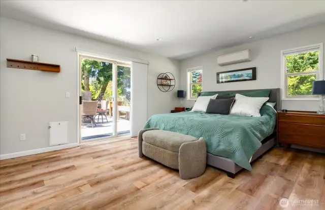Primary bedroom with sliding glass doors leading out on the deck.