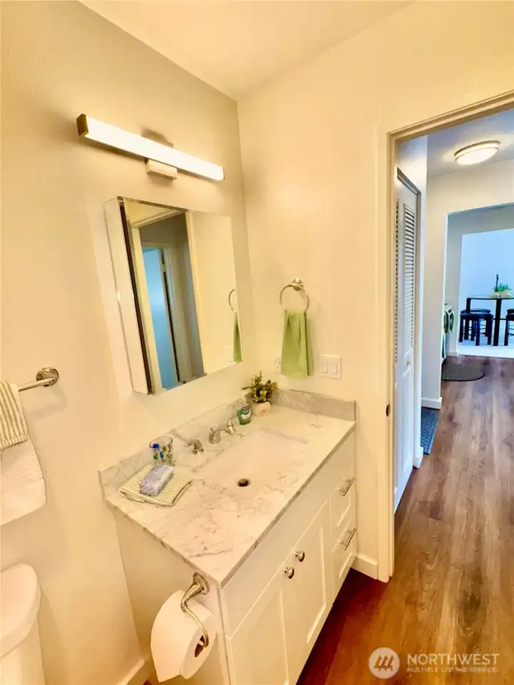 All new bath fixtures. Quartz counters here too. New laminated wood flooring thru to the dining area.