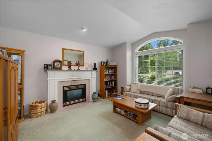 Cozy living room offers gas fireplace, large window and slightly vaulted ceilings.