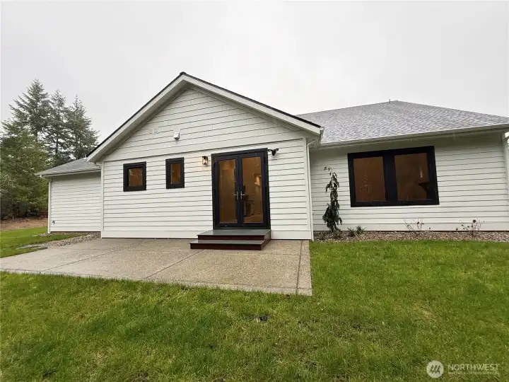 BACK OF HOUSE WITH LARGE CONCRETE PATIO FOR LOW MAINTENANCE