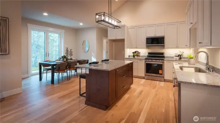 The kitchen is complemented by a light-filled dining nook, perfectly positioned for casual meals or morning coffee. Surrounded by windows, this space feels bright and cheerful, offering a relaxed setting just off the main kitchen area.