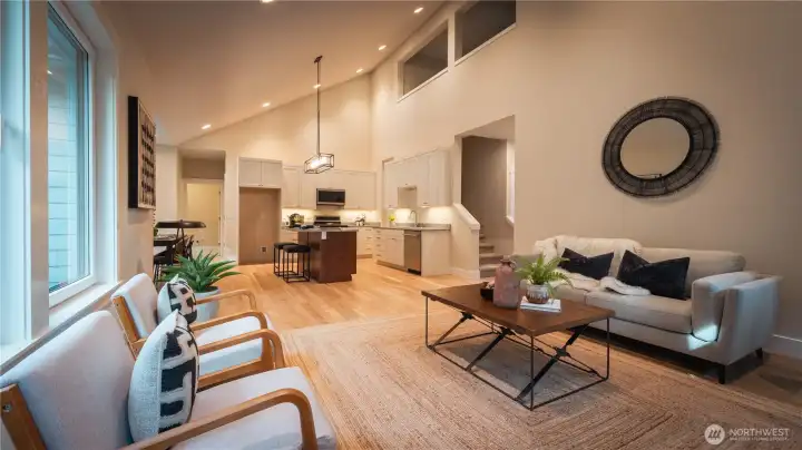 This perspective showcases the kitchen’s connection to the main living area, emphasizing the open-concept design. The kitchen features ample counter space and a layout that supports both function and flow, with sightlines directly into the great room. This setup is perfect for staying engaged with family or guests while cooking. The continuity of finishes—especially the flooring and overall design—creates a cohesive and inviting space.