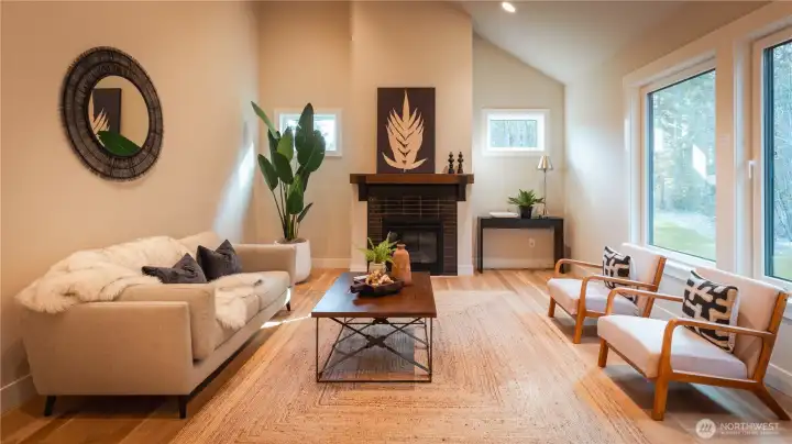 The great room stands out with its soaring ceilings and spacious layout. Natural light pours in, highlighting the rich flooring and open design. The fireplace adds both style and comfort, making this an ideal space to unwind or entertain.