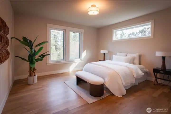 The primary suite offers a peaceful retreat with ample space and soft natural light. Clean lines and a neutral palette create a calm, relaxing environment, while the layout allows for comfortable furniture placement and easy flow.