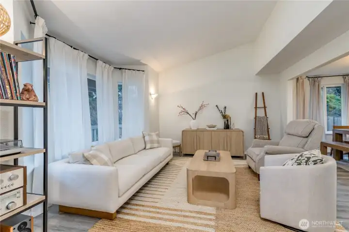 Formal living room features big windows and vaulted ceiling