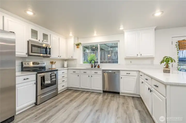 Crisp white kitchen with quartz counters, stainless appliances