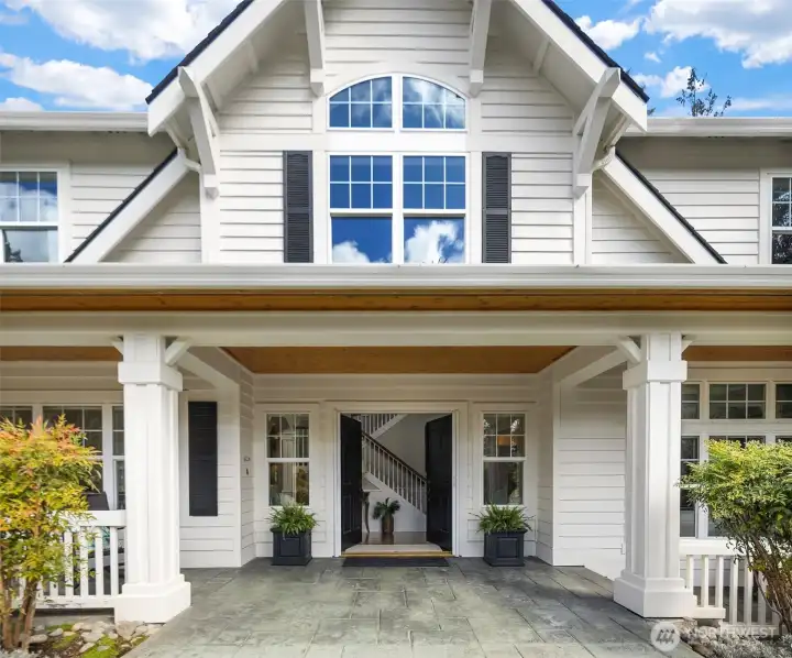 Dramatic front covered porch with seating and wood soffits