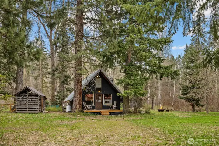 Welcoming front deck framed by towering pines.