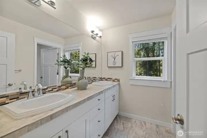 Upstairs bathroom serving the secondary bedrooms. Tile flooring.