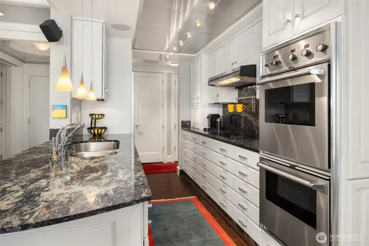 Custom wood cabinets and lighting, granite finishes, quality fixtures & parquet floors. Walk through galley kitchen opens to living and dining spaces.