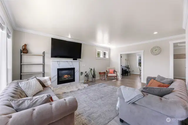 Lots of light, quartz wrapped fireplace, tall trim and crown molding throughout!